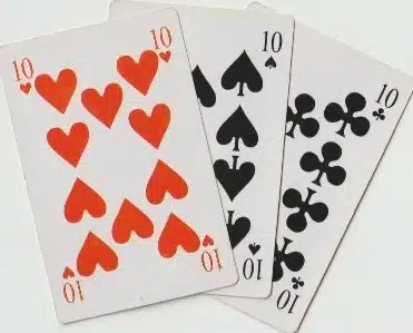 Trois cartes à jouer (cœur rouge, pique noir, trèfle noir) montrant des suites/valeurs, numéro 10 en haut et en bas, sur fond clair. alt: regle rami