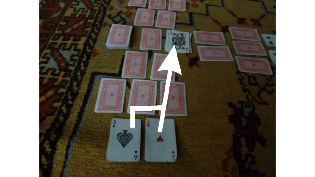 Cartes alignées au jeu du Canard avec une flèche indiquant la rangée visée